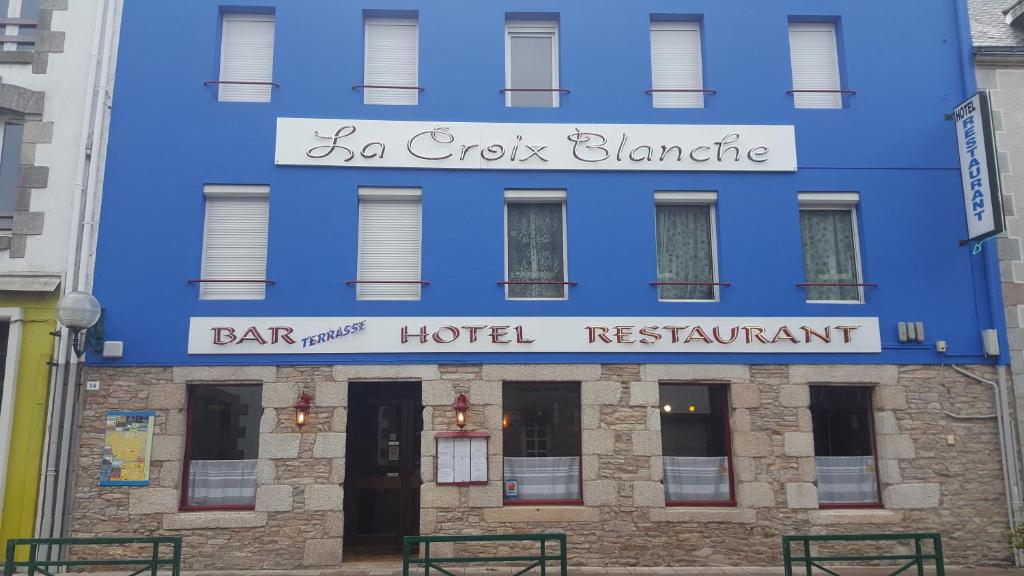 un edificio azul con un letrero que lee bar y restaurante del hotel en La Croix Blanche, en Pluvigner