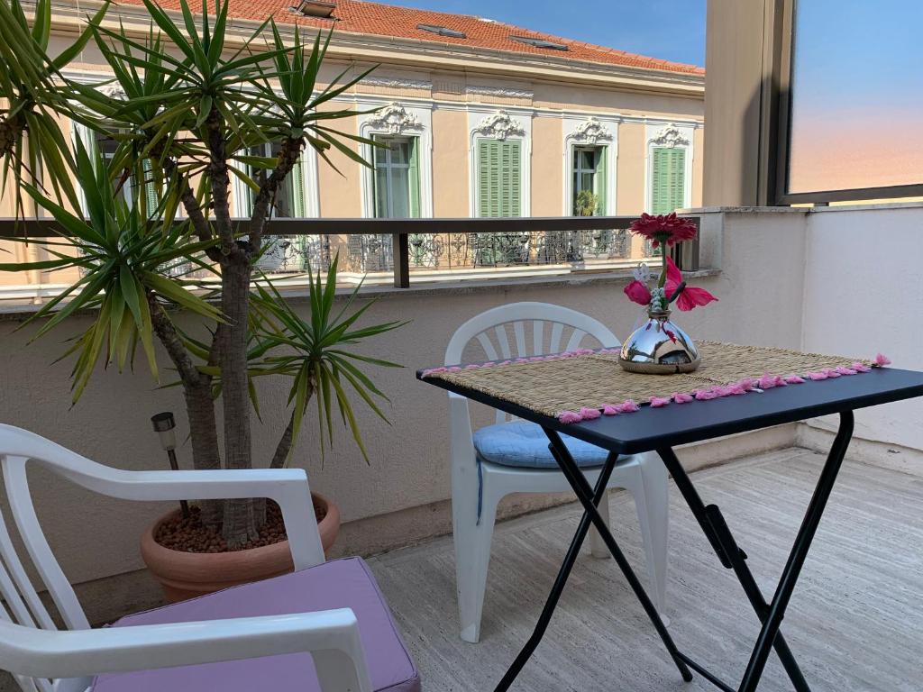 una mesa y sillas en un balcón con una planta en Gray d' Albion Apartment, en Cannes