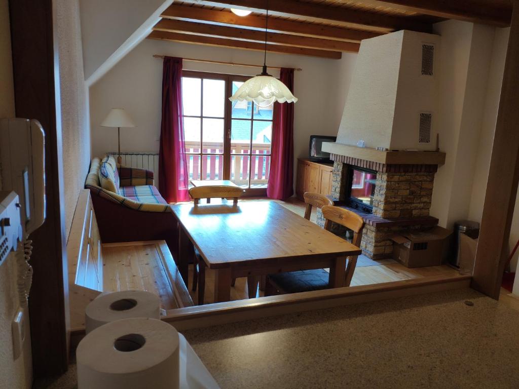 een woonkamer met een tafel en een open haard bij Antela appartments for up to 5 person on Mariborsko Pohorje in Hočko Pohorje