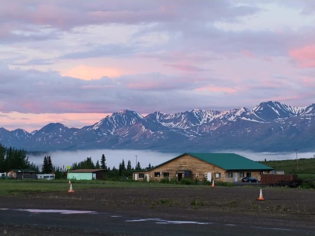 a house with a mountain range in the background at Cantwell Lodge in Cantwell