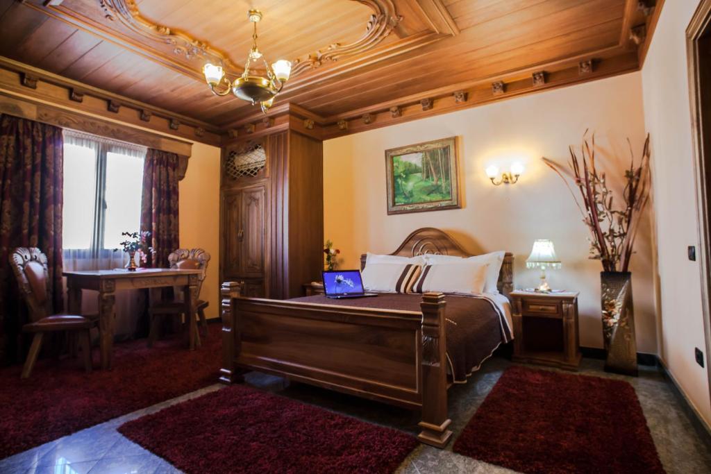 a bedroom with a bed with a laptop on it at Brilant Antik Hotel in Tirana