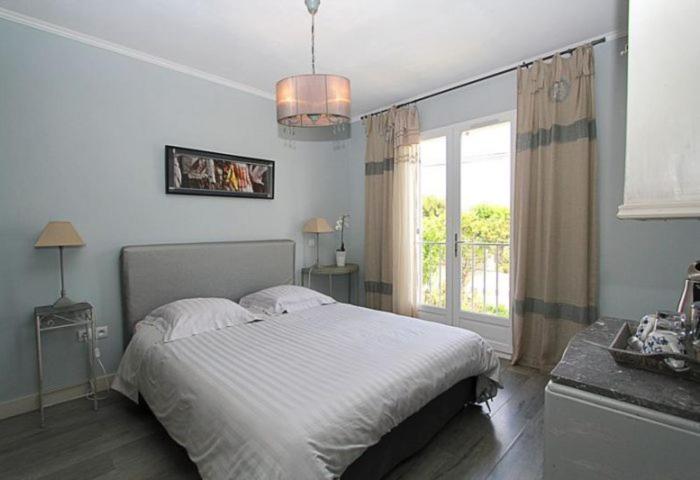 a bedroom with a large bed and a window at Le Clos du Jas in Marseille