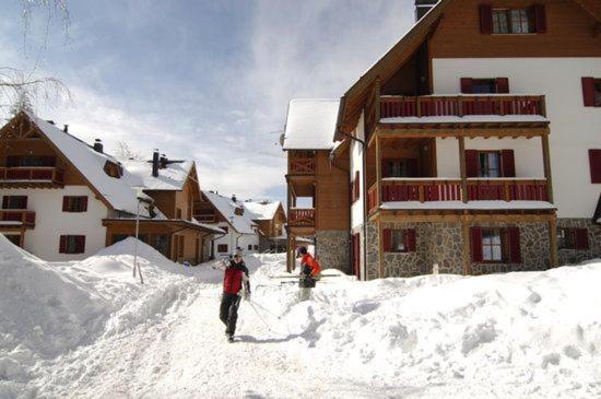 twee mensen in de sneeuw voor een lodge bij Antela, 142 m2 appartment for 12 person in Mariborsko Pohorje in Hočko Pohorje