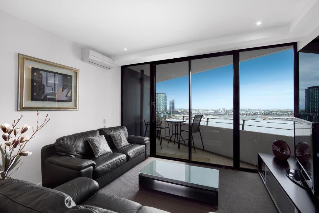 a living room with a couch and a table at Docklands Private Collection - NEWQUAY in Melbourne