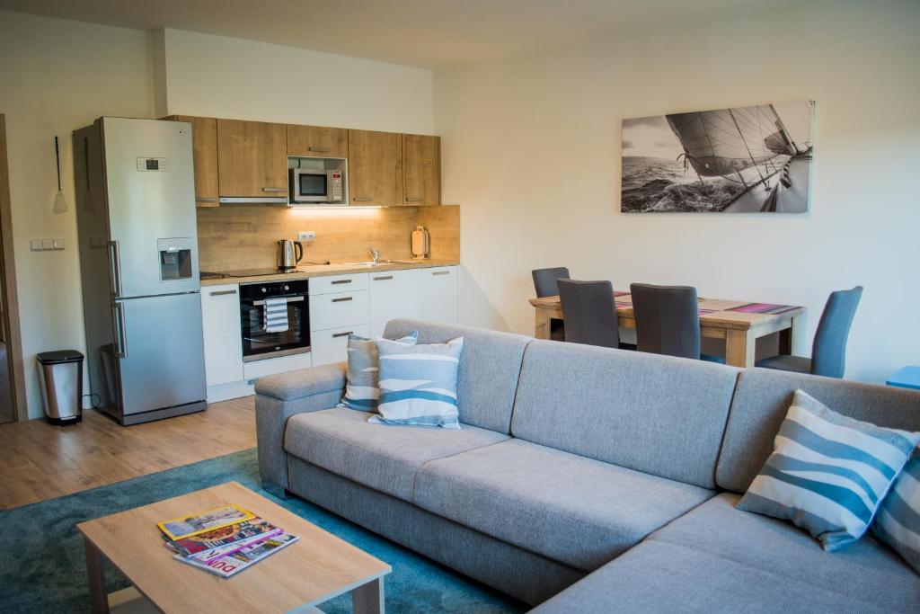 a living room with a couch and a kitchen at Apartmán Laura, Frymburk in Frymburk