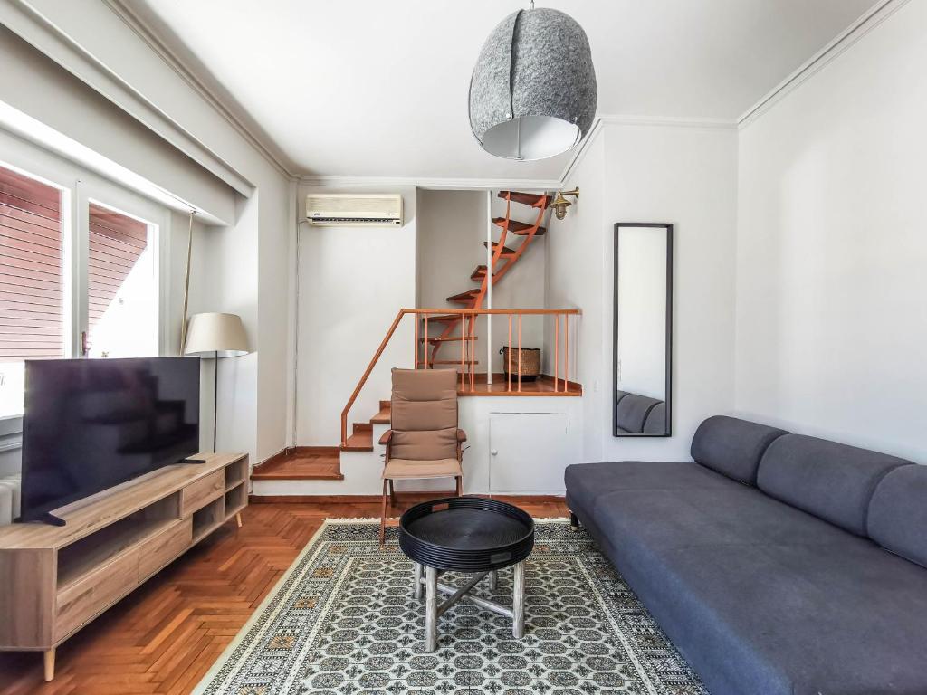 a living room with a couch and a television at Acropolitana Grand view veranda in Athens