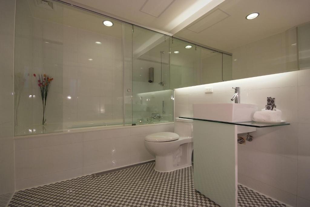 a bathroom with a toilet and a shower and a sink at Hotel Purity in Xinzhuang