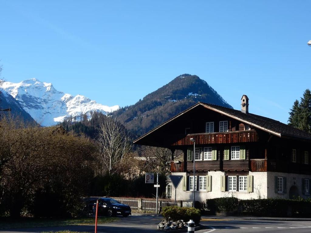 a large building with a mountain in the background at Traditional Swiss-Flat in Interlaken
