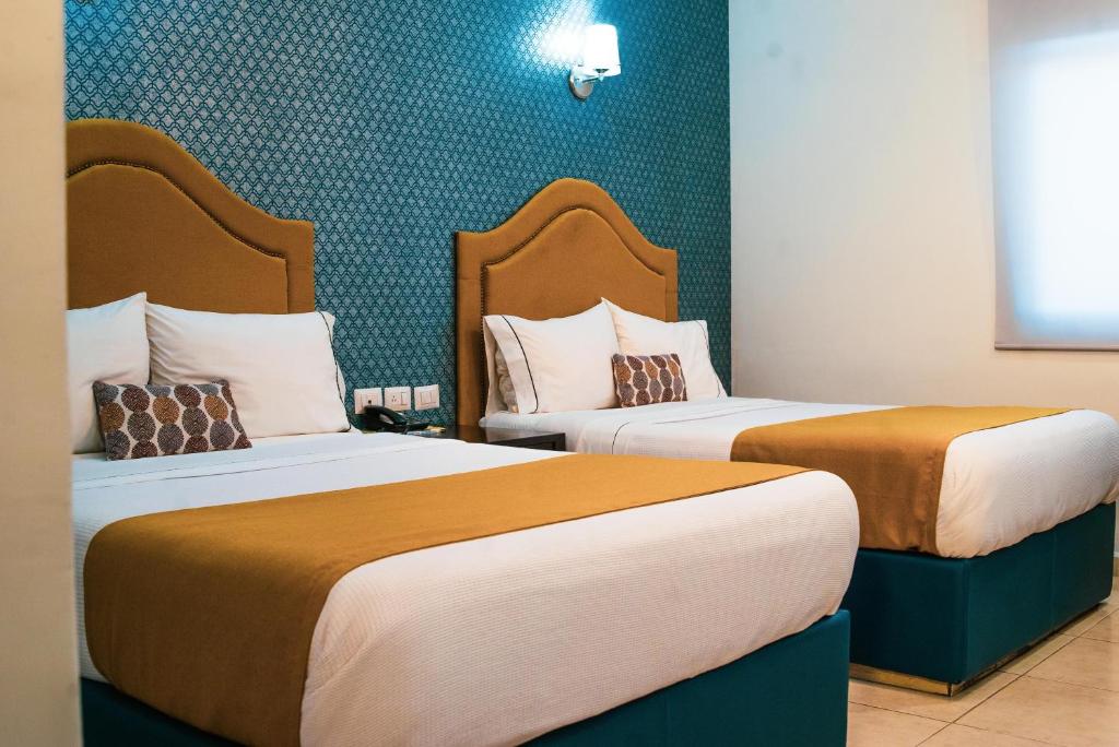 Dos camas en una habitación de hotel con 2 camas Sidx Sidx en Hotel Maioris Kumate Culiacán, en Culiacán