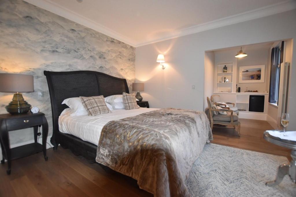 a bedroom with a large bed with a stone wall at Watersmeet Hotel in Woolacombe