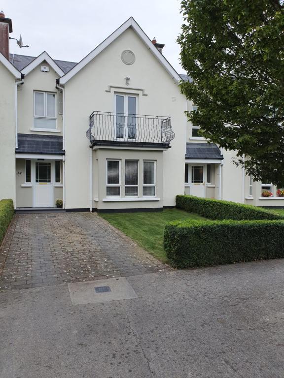 uma casa branca com uma varanda e uma entrada em Wolseley Park guest house em Tullow