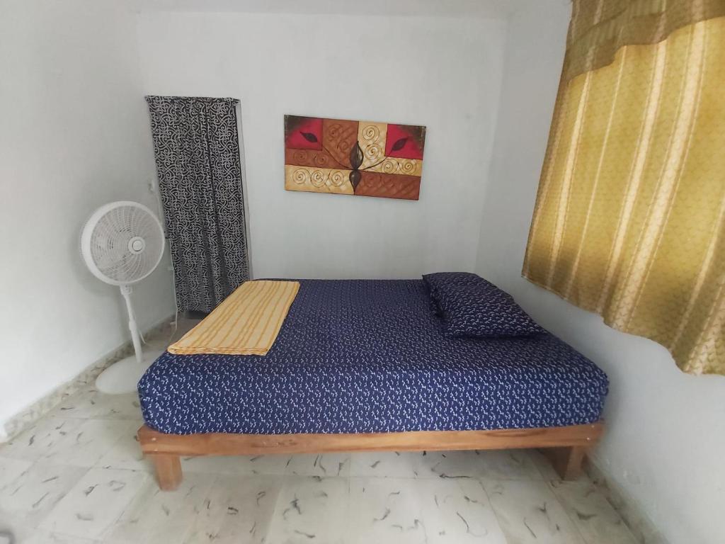 a small bedroom with a bed in a room at Delmar Hostal in Bacalar