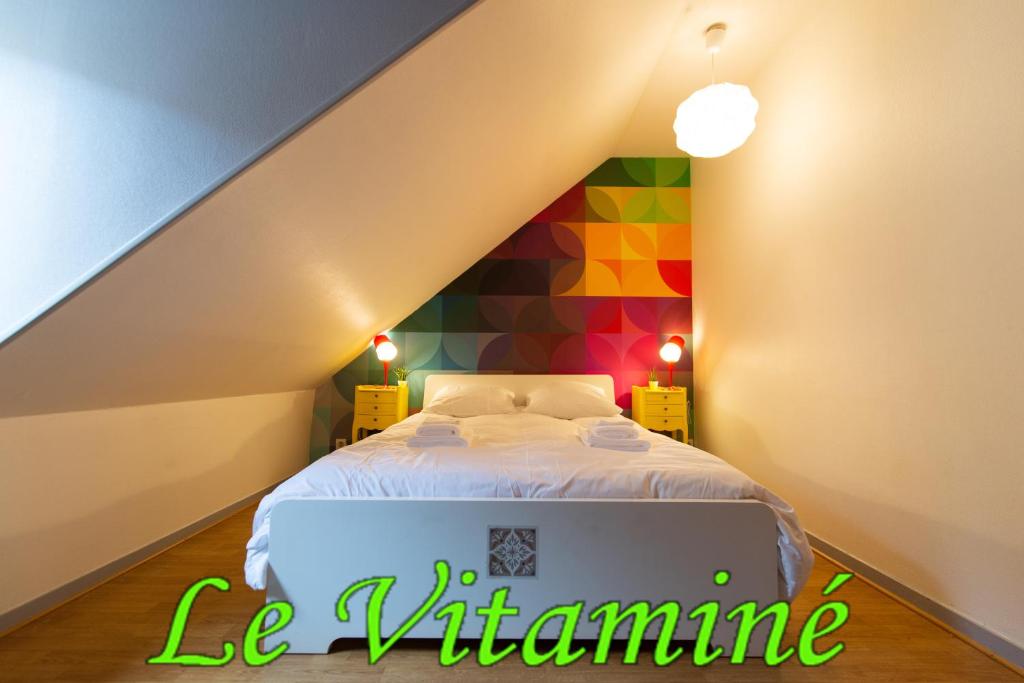 1 dormitorio con 1 cama con una pared colorida en APPARTEMENT LE VITAMINE - topbnb dijon, en Dijon