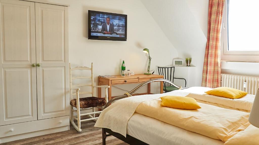 a bedroom with two beds and a table and a desk at Hotel 3 Könige in Aachen