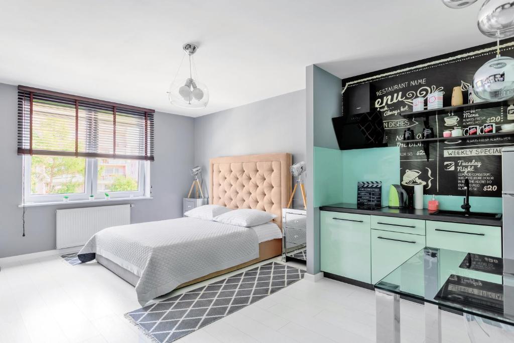 オルシュティンにあるHamak Apartamentyのベッドルーム1室(ベッド1台付)、壁にチョークボードが備わります。