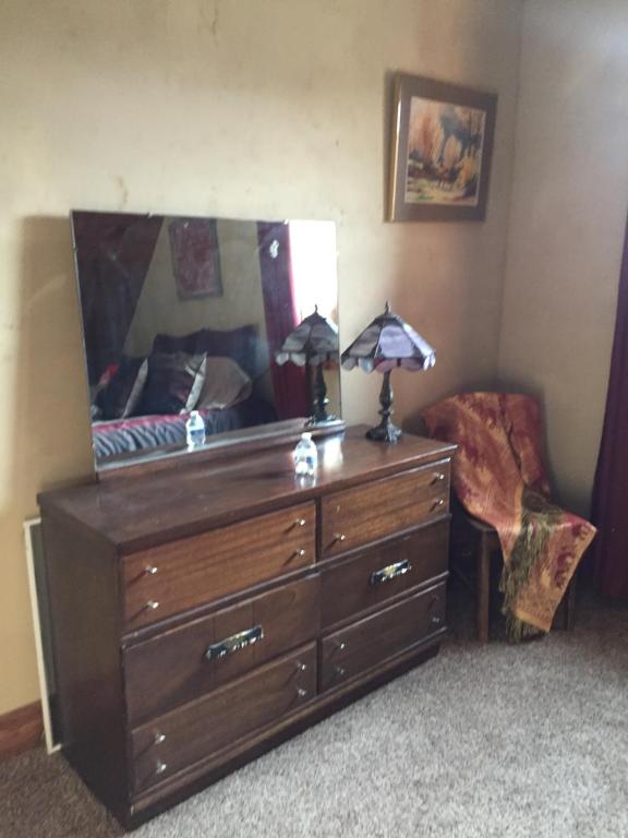 a dresser with two lamps and a chair in a room at The Old Church B&B in Warner