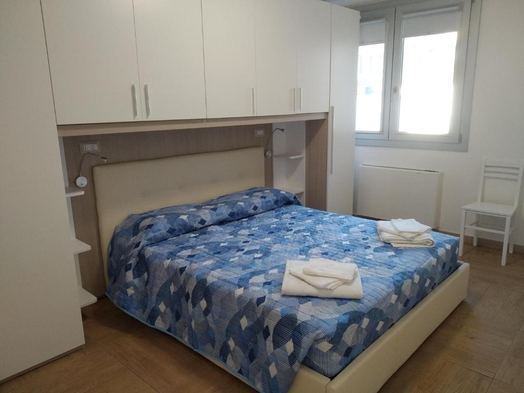a bedroom with a bed with two towels on it at ORISTANO CAMERA BLU max 2 pers, BAGNO E USO CUCINA in Oristano