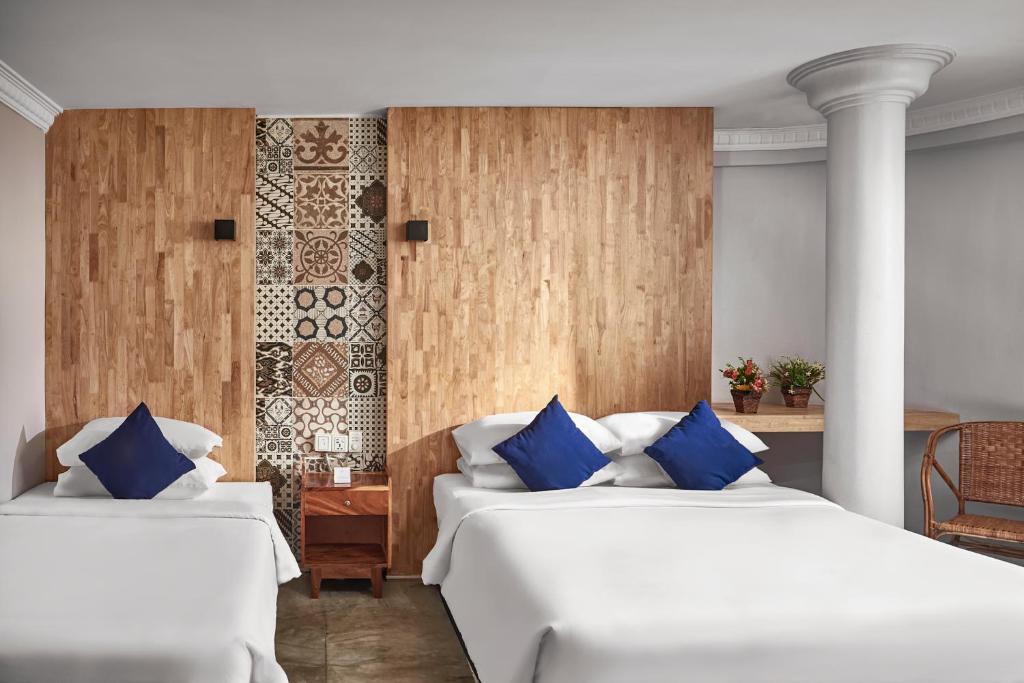 duas camas num quarto de hotel com almofadas azuis em Pacific Hotel em Phnom Penh