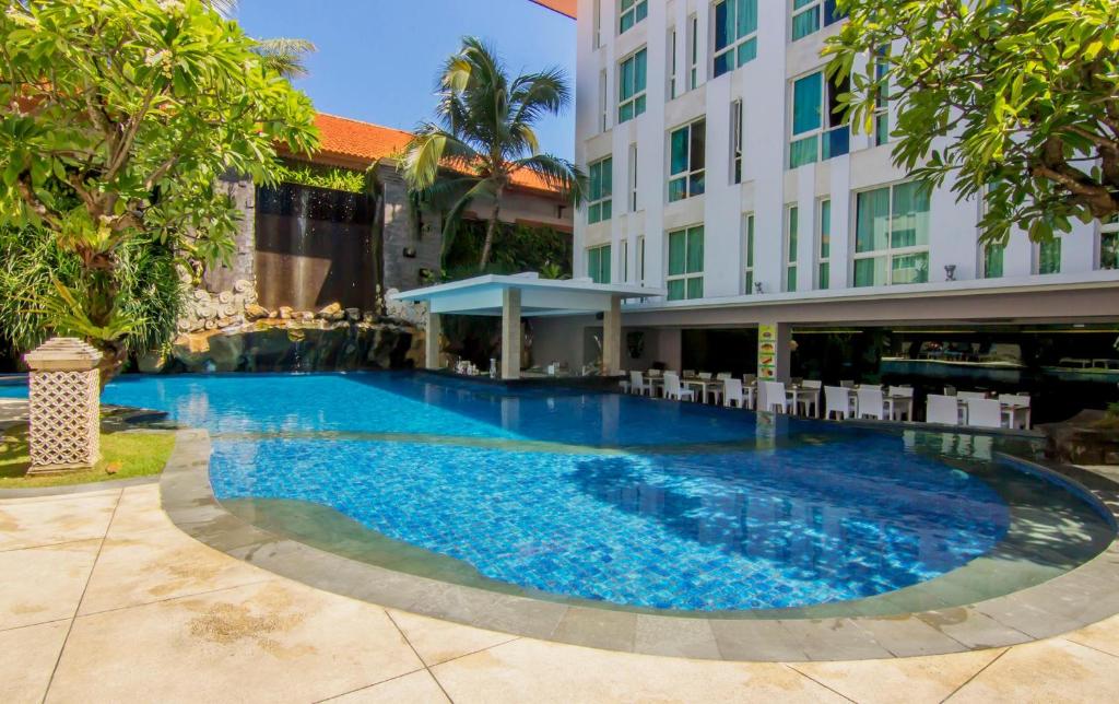 a large swimming pool in front of a building at Bintang Kuta Hotel in Kuta