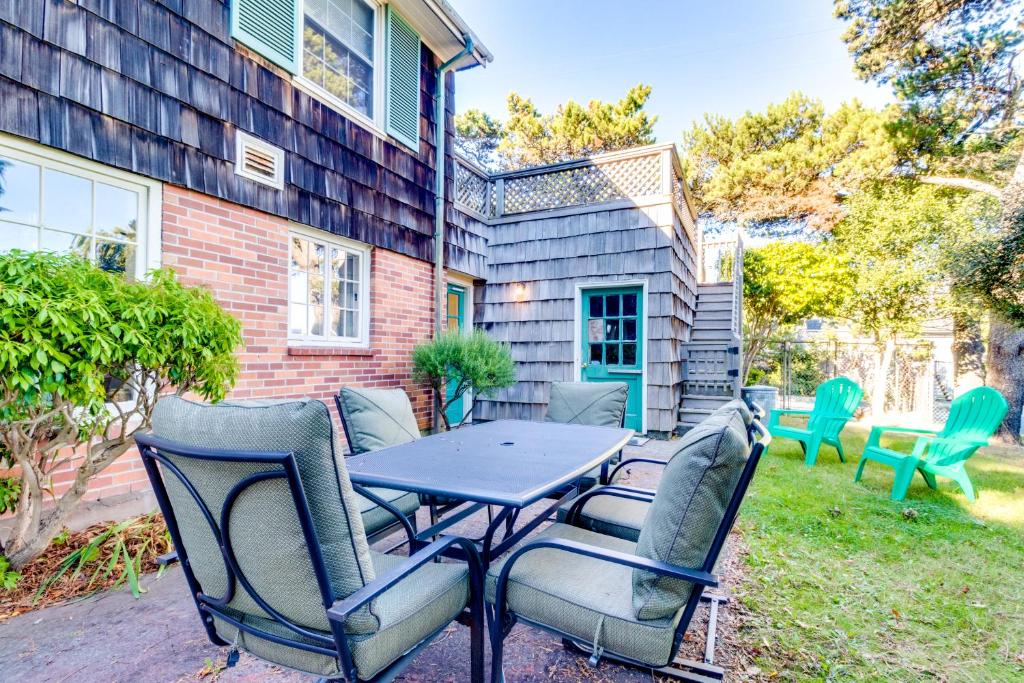 a patio with a table and chairs in a yard at Seaside Governor's House Vacation Rental in Seaside