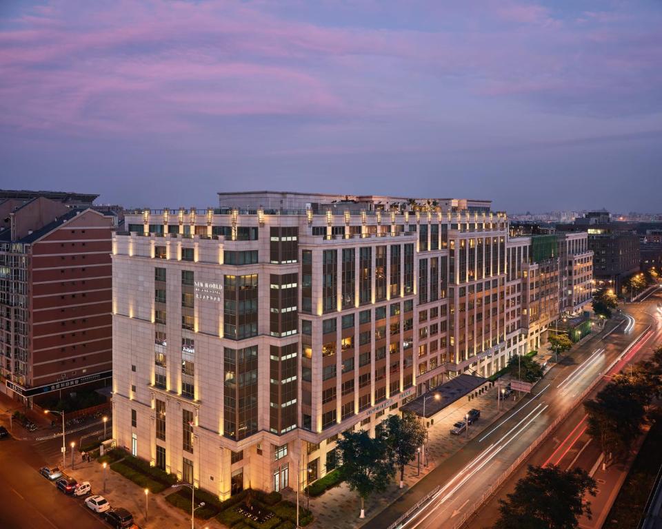 een groot gebouw in een stadsstraat 's nachts bij New World Beijing Hotel in Beijing