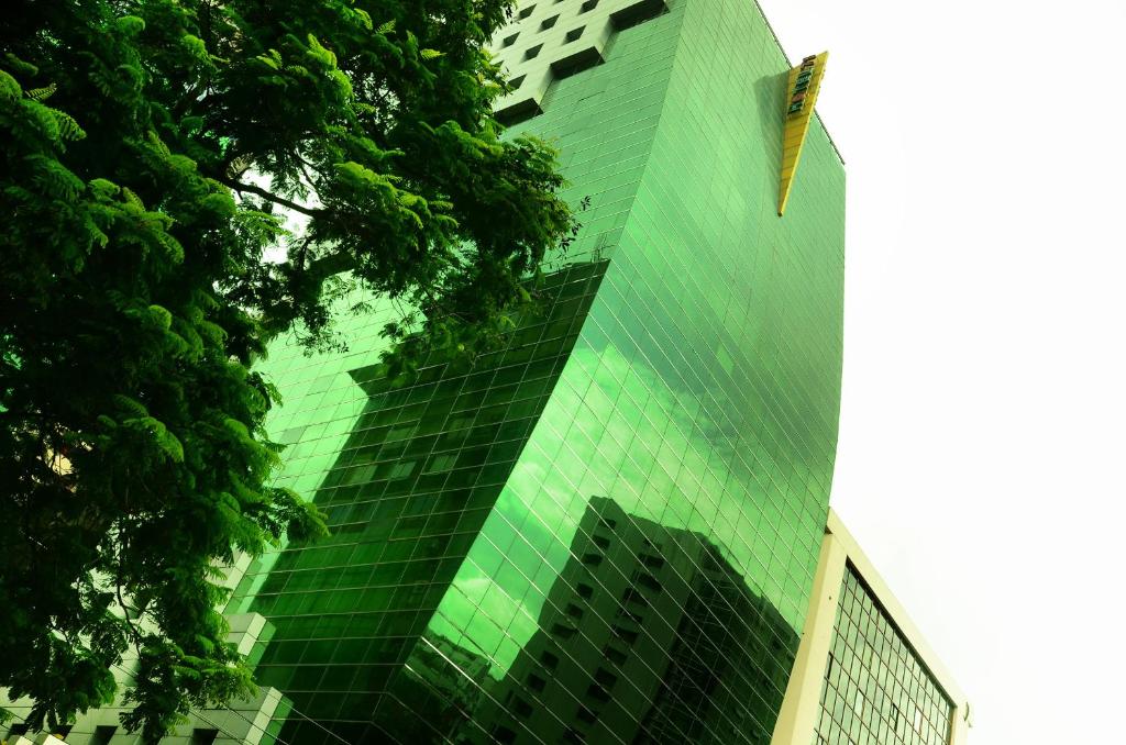 a tall green building with a lot of windows at Hotel 71 in Dhaka