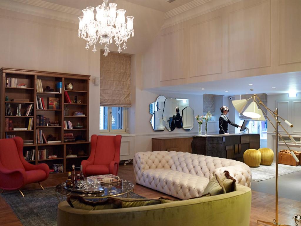 a living room with a white couch and red chairs at Marpessa Hotel & Spa in Agrinion