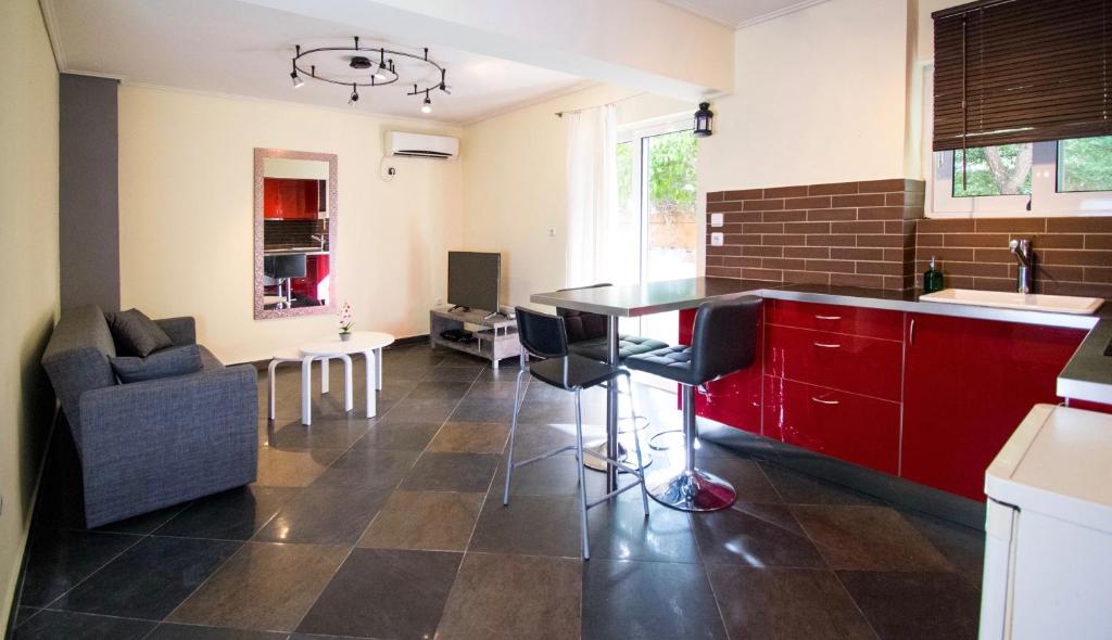 une cuisine avec des placards rouges et un salon dans l'établissement SEASIDE SUNSET WALKS, à Athènes