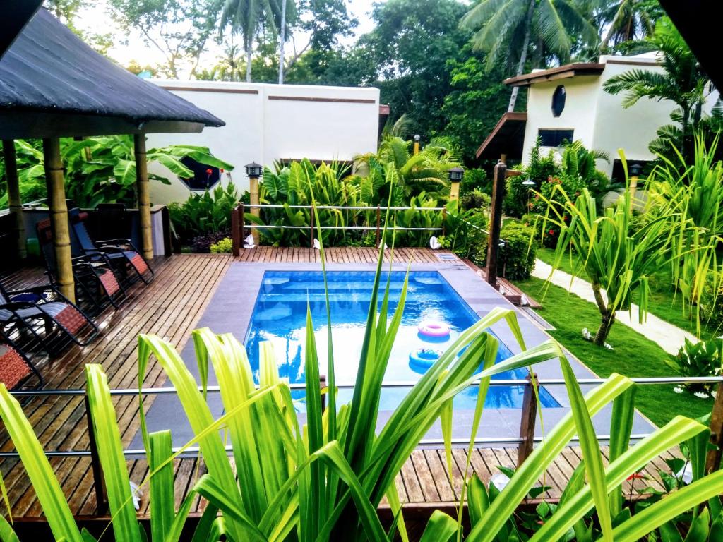 - une piscine dans une cour ornée de plantes dans l'établissement Siargao Sunset Bay Beach Villas, à General Luna