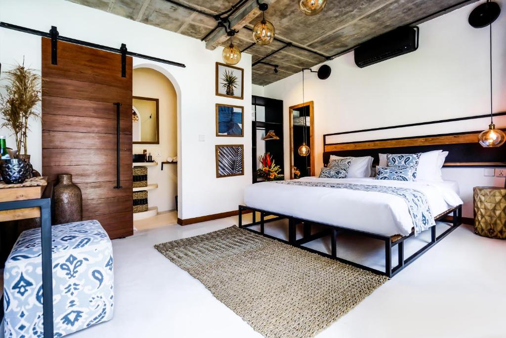 a bedroom with a large bed with a wooden headboard at Body Factory Bali in Canggu