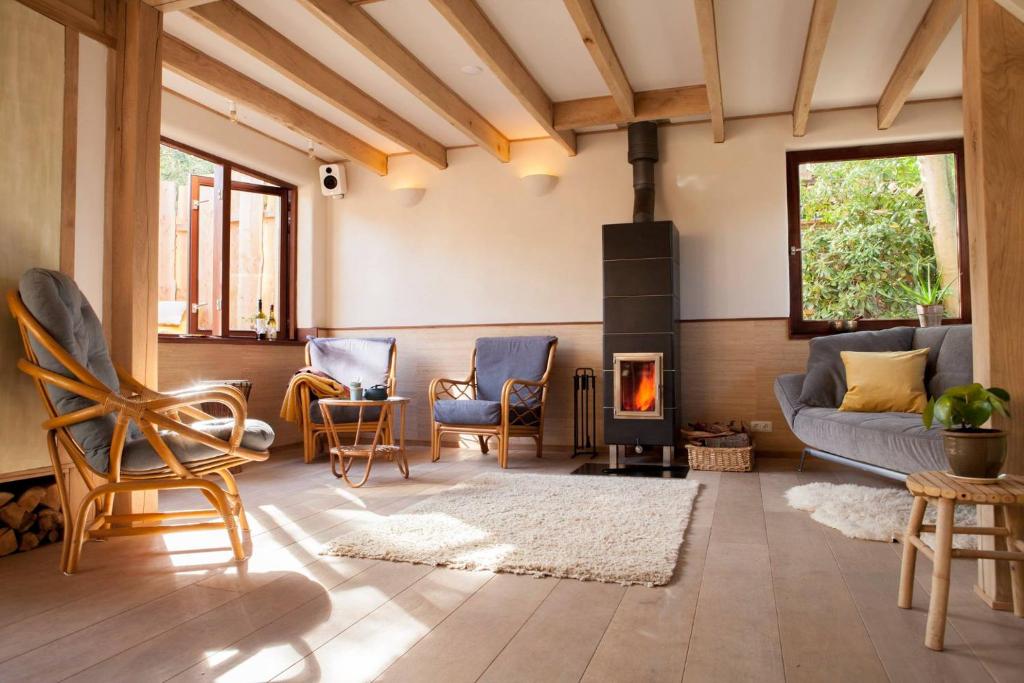 a living room with a couch and a fireplace at Ecolodge de Parel Schoorl in Schoorl