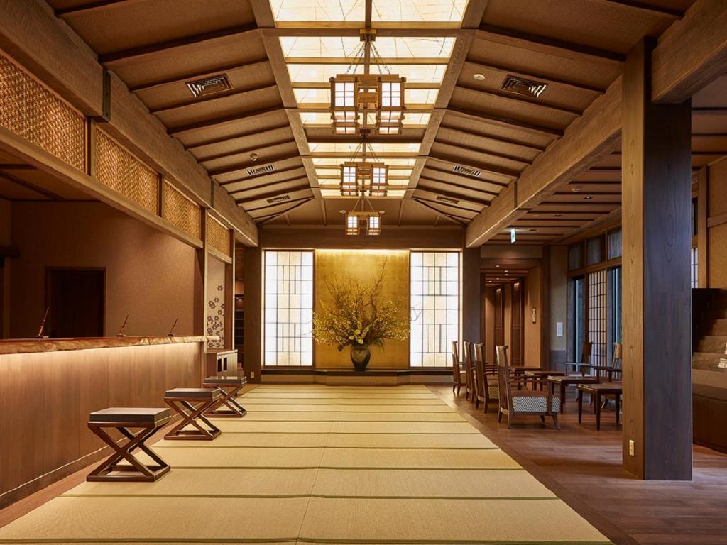 a large room with a table and chairs and windows at Yukinohana in Yuzawa