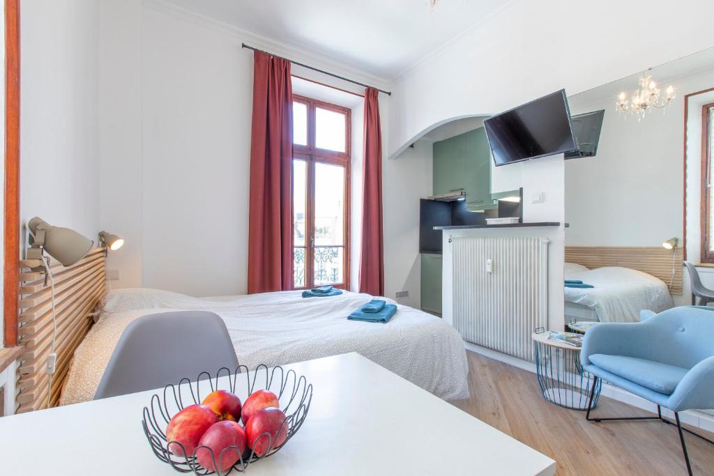 une chambre d'hôtel avec un lit et un bol de fruits sur une table dans l'établissement Le Terminus Studio Hyper Centre Fibre Optique, à Aix-les-Bains