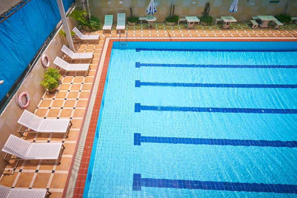an overhead view of a swimming pool with white chairs at Sivalai Place in Bangkok