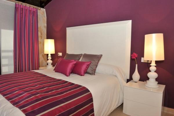 een slaapkamer met een groot bed met paarse muren bij El Balcon Del Cañon in Ucero