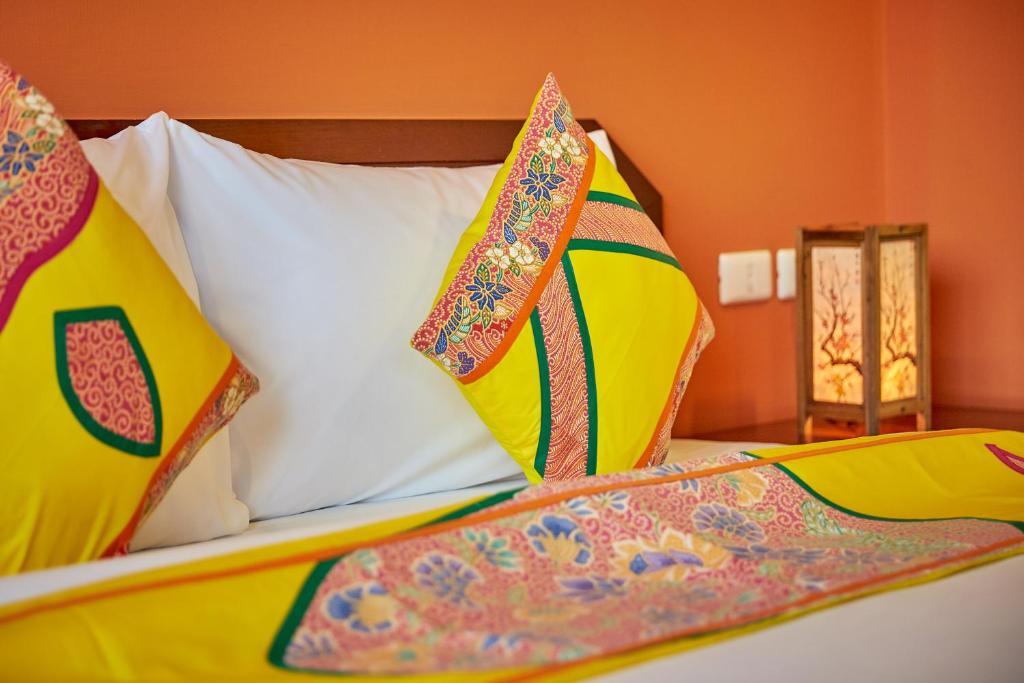 a bed with colorful pillows on top of it at Sivalai Place in Bangkok