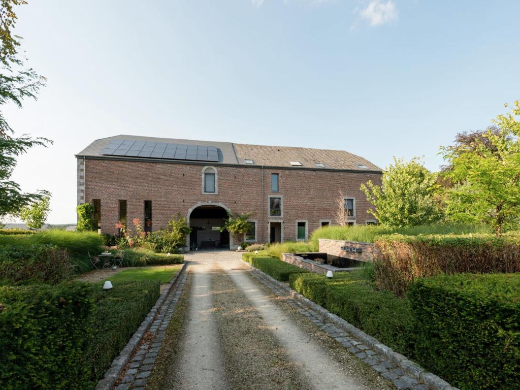 a large brick building with a pathway in front of it at Magnificent character cottage with hot tub in Marche-en-Famenne