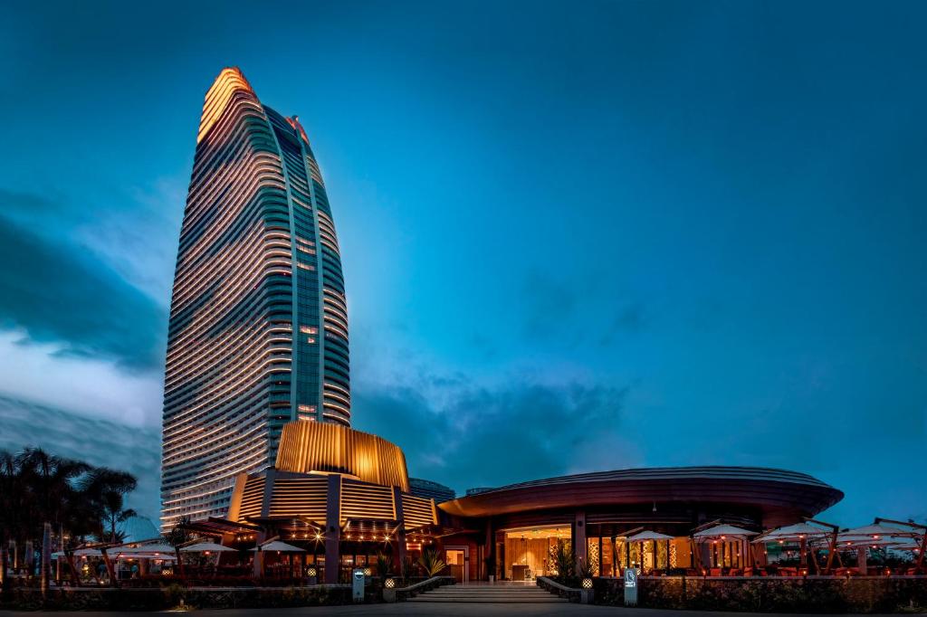 um edifício alto com um restaurante em frente em Atlantis Sanya em Sanya