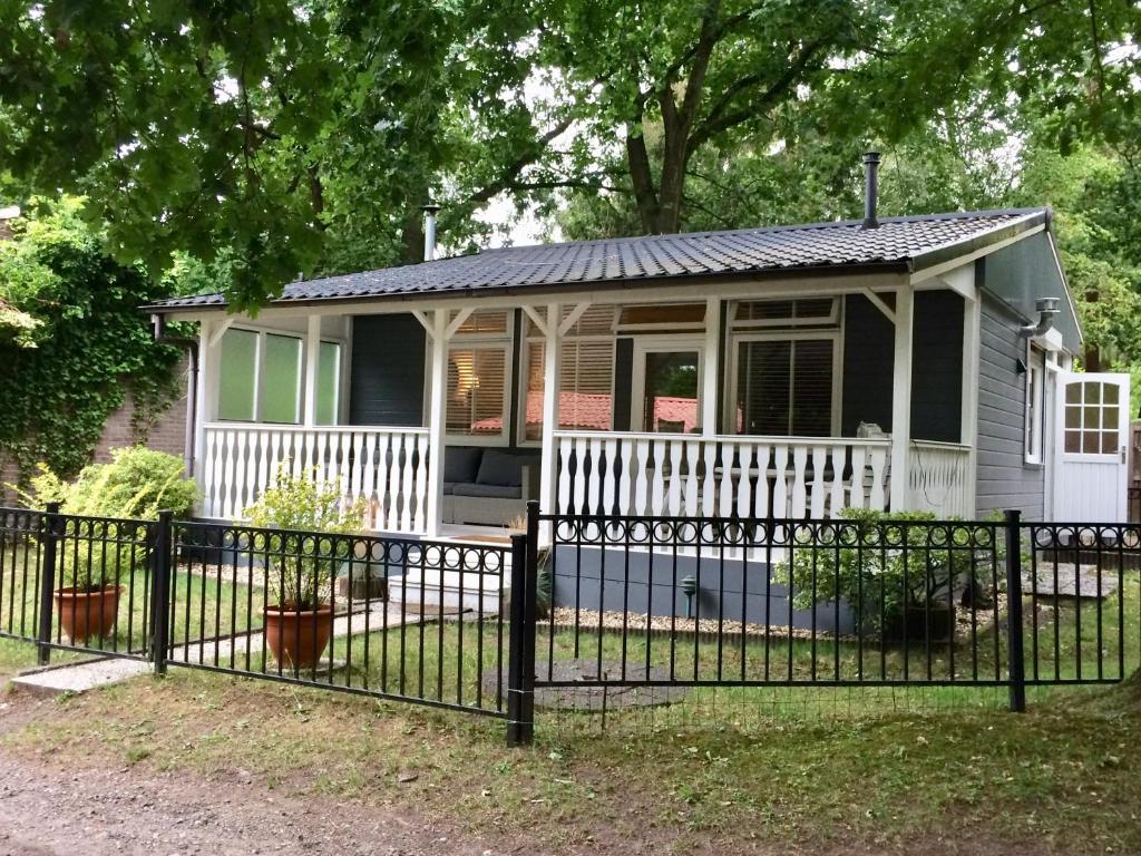 ein kleines Haus mit einem Zaun davor in der Unterkunft Chalet Belvedere in Lanaken in Lanaken