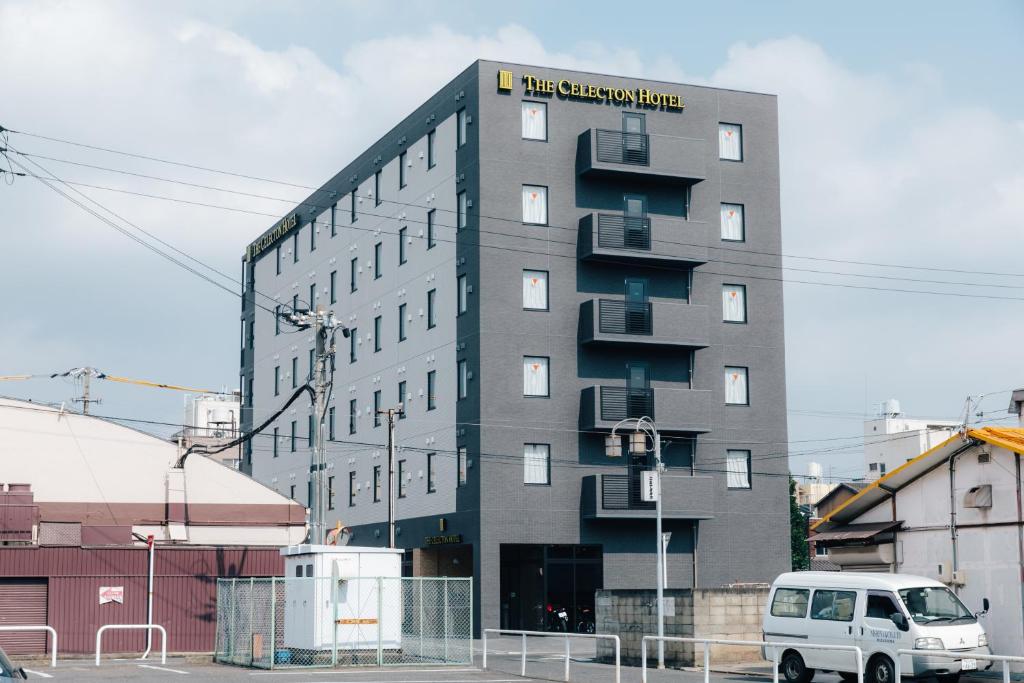 un bâtiment avec une camionnette blanche garée devant lui dans l'établissement The Celecton Kurashiki Mizushima, à Kurashiki