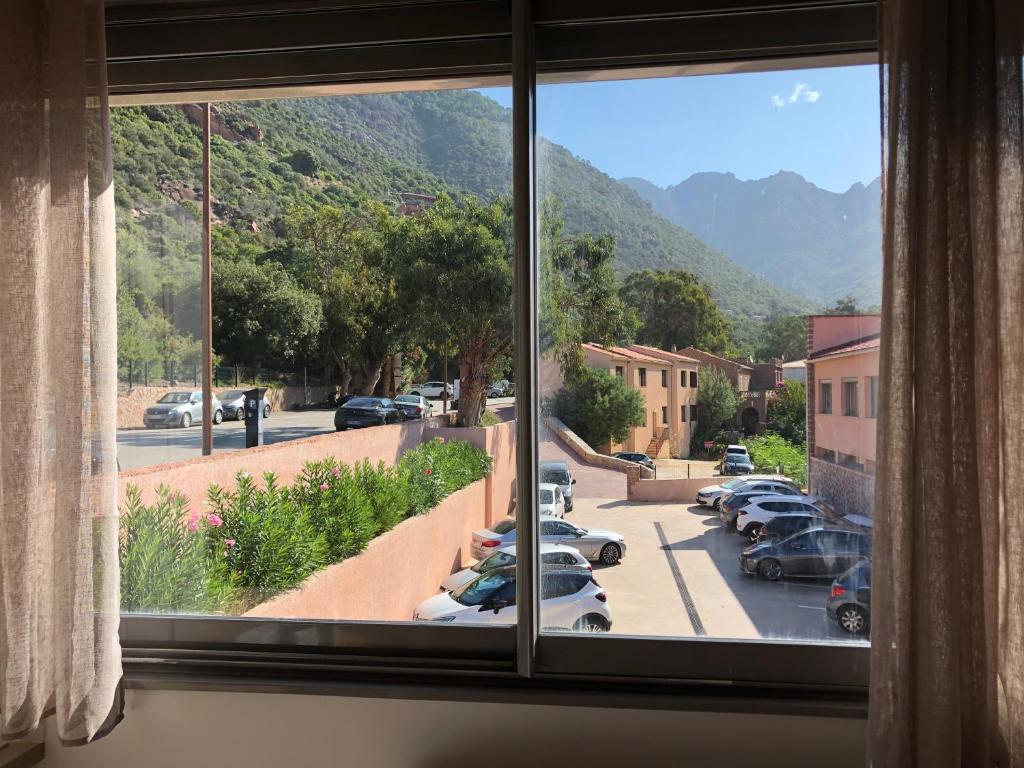 a window with a view of a parking lot at Résidence Porto Marine in Porto Ota