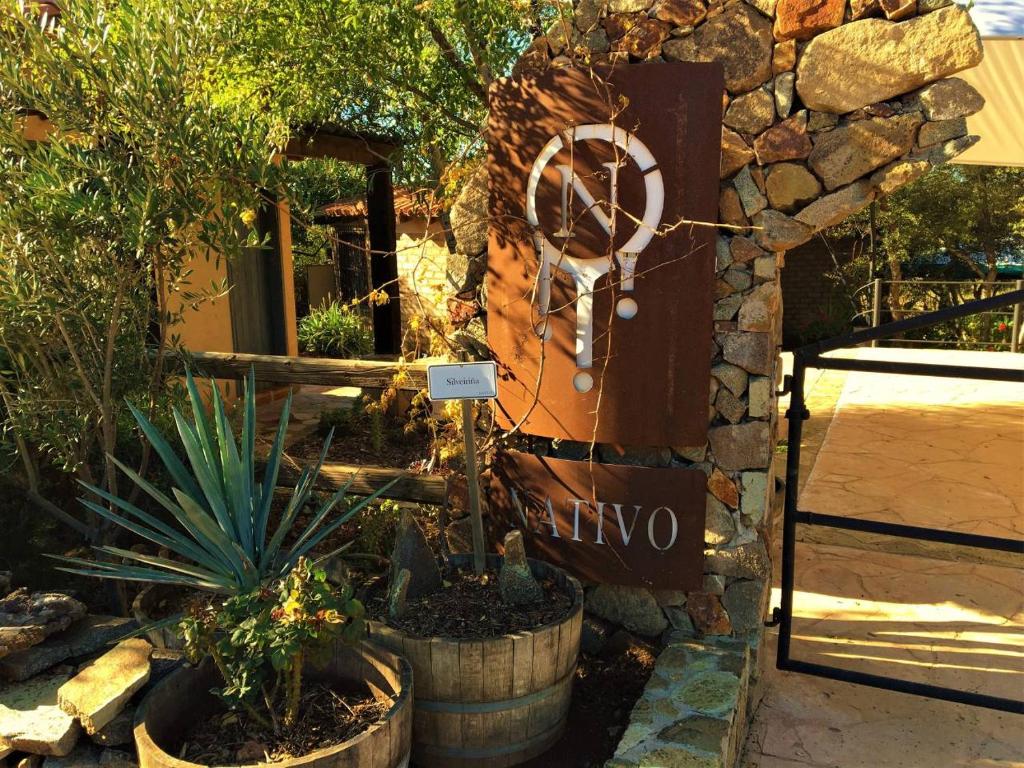 a sign for a garden with plants in barrels at Casa Nativo - The Heart of the Vineyard in Valle de Guadalupe