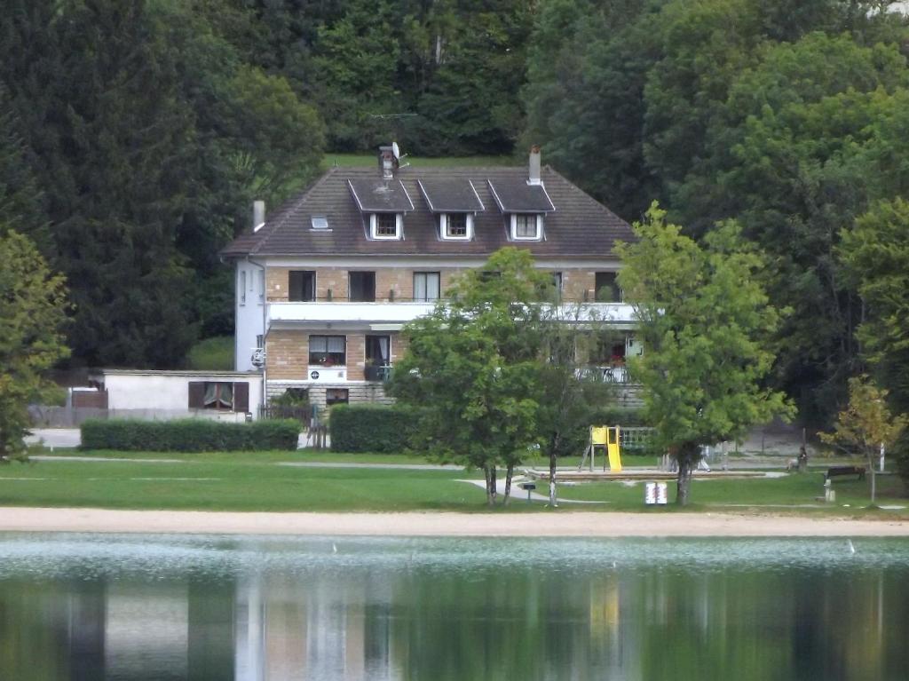 クレルヴォー・レ・ラックにあるHotel Restaurant La Chaumiere du Lacの湖畔に座る大家