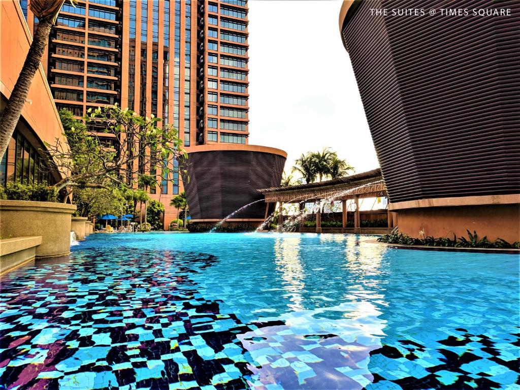 una piscina con agua azul en una ciudad con edificios altos en The Suites at Times Square KL, en Kuala Lumpur