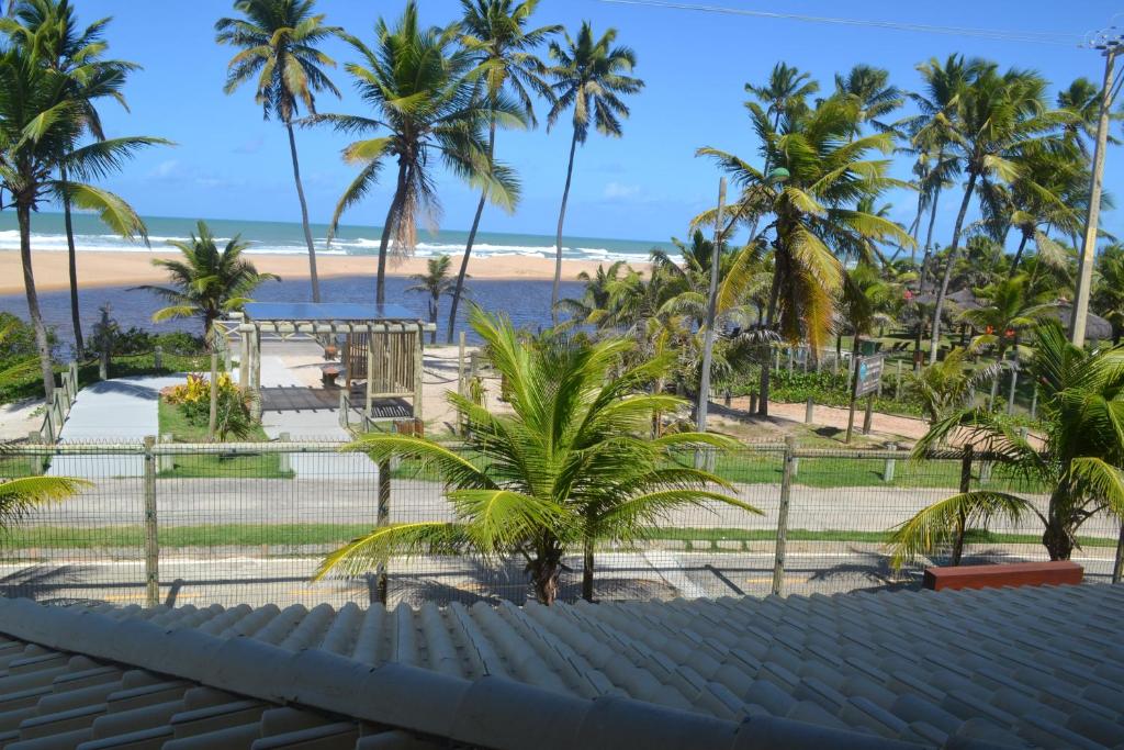 uma vista para a praia a partir da varanda de um resort em Paraiso Praia de Imbassai - Ykutiba S-001 - Duplex frente mar em Imbassaí