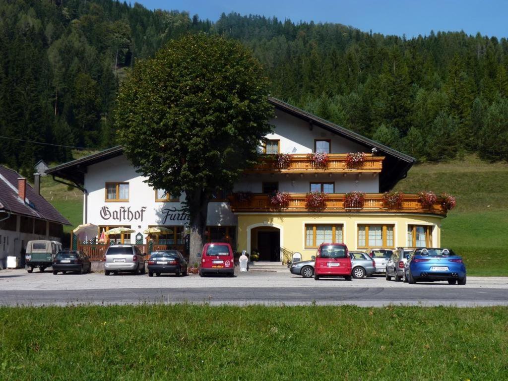 a large building with cars parked in front of it at Gasthof Furtner in Rohr im Gebirge