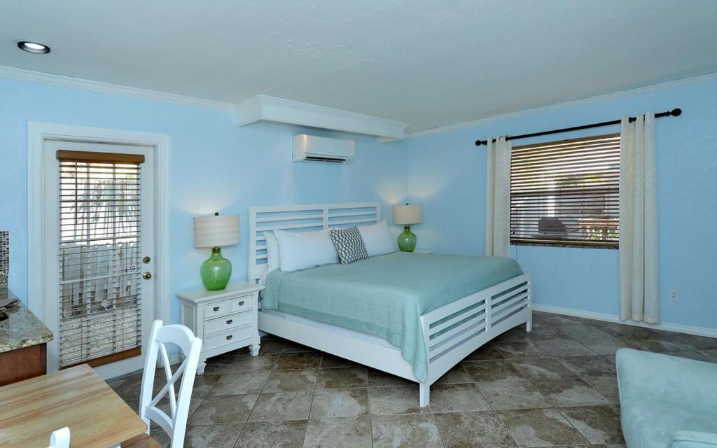 een blauwe slaapkamer met een bed en een tafel bij Coriander Cottage in Siesta Key