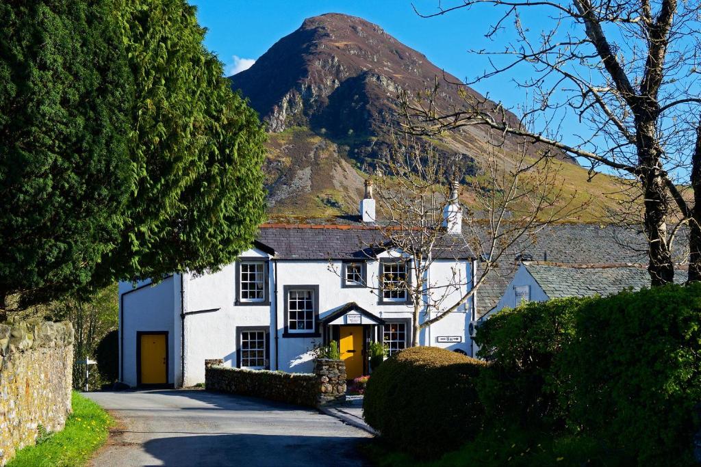 a white house with a mountain in the background at Kirkstile Inn in Loweswater