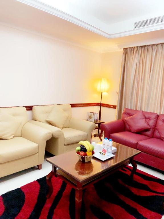 a living room with two couches and a coffee table at Hala Inn Hotel Apartments - BAITHANS in Ajman 