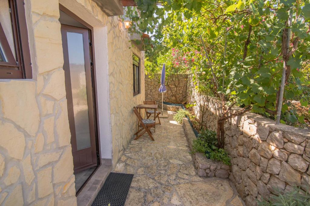 a pathway leading to a house with a door and a chair at Bato A2+1 in Veli Lošinj